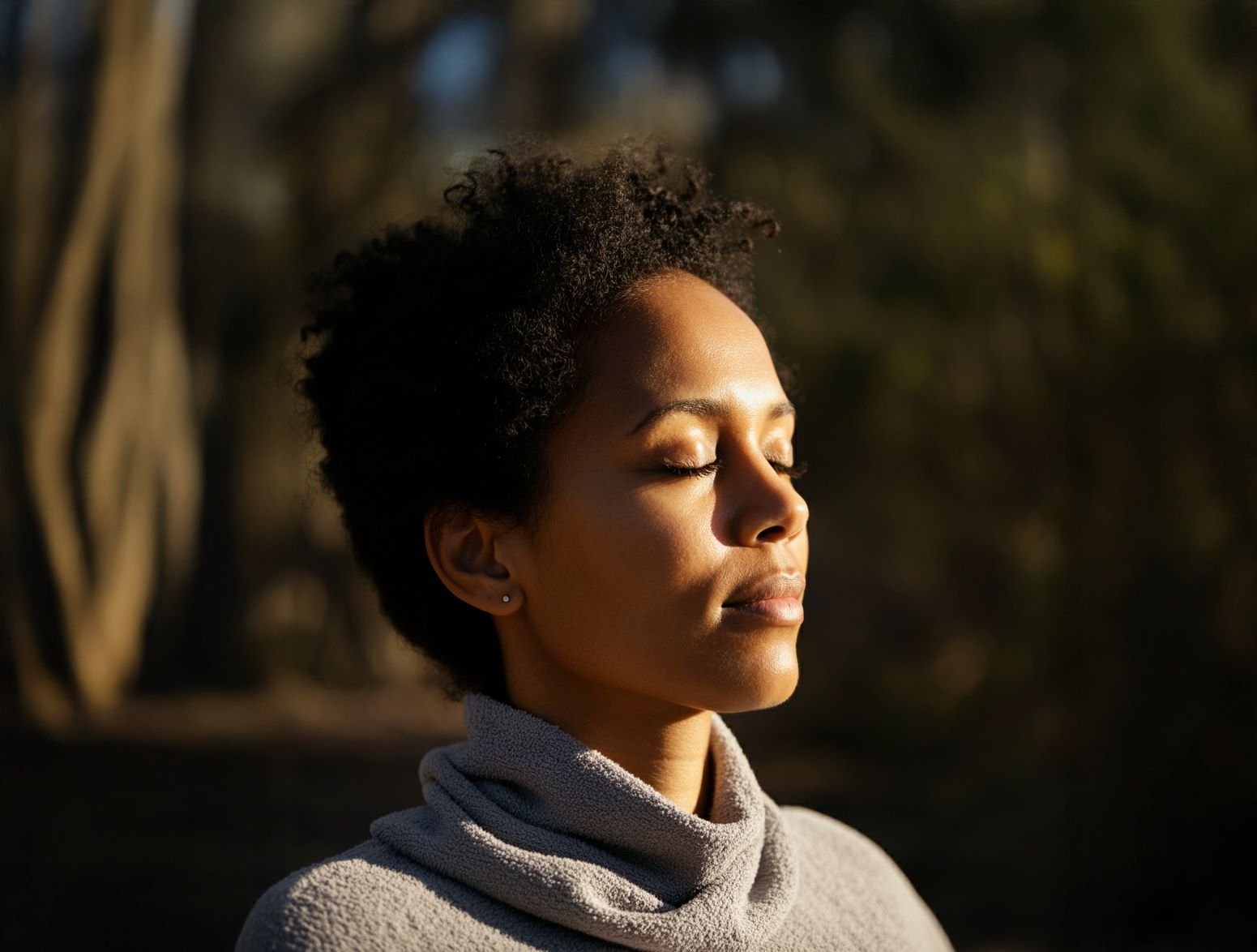 一位黑人女性闭着眼睛，面朝太阳，散发出平静与解脱的气息。 