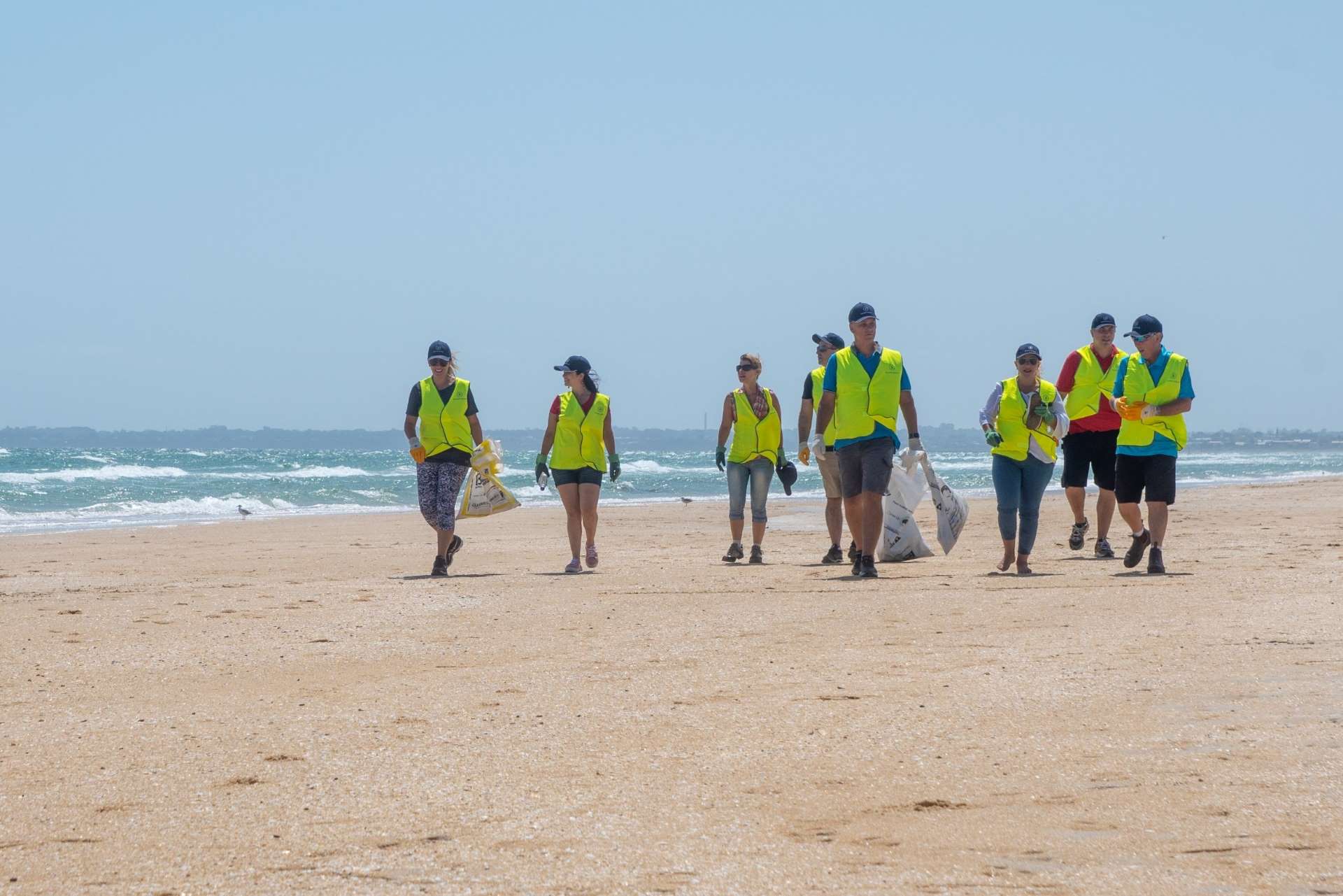 Empleados de BekaertDeslee limpiando la playa de residuos plásticos.