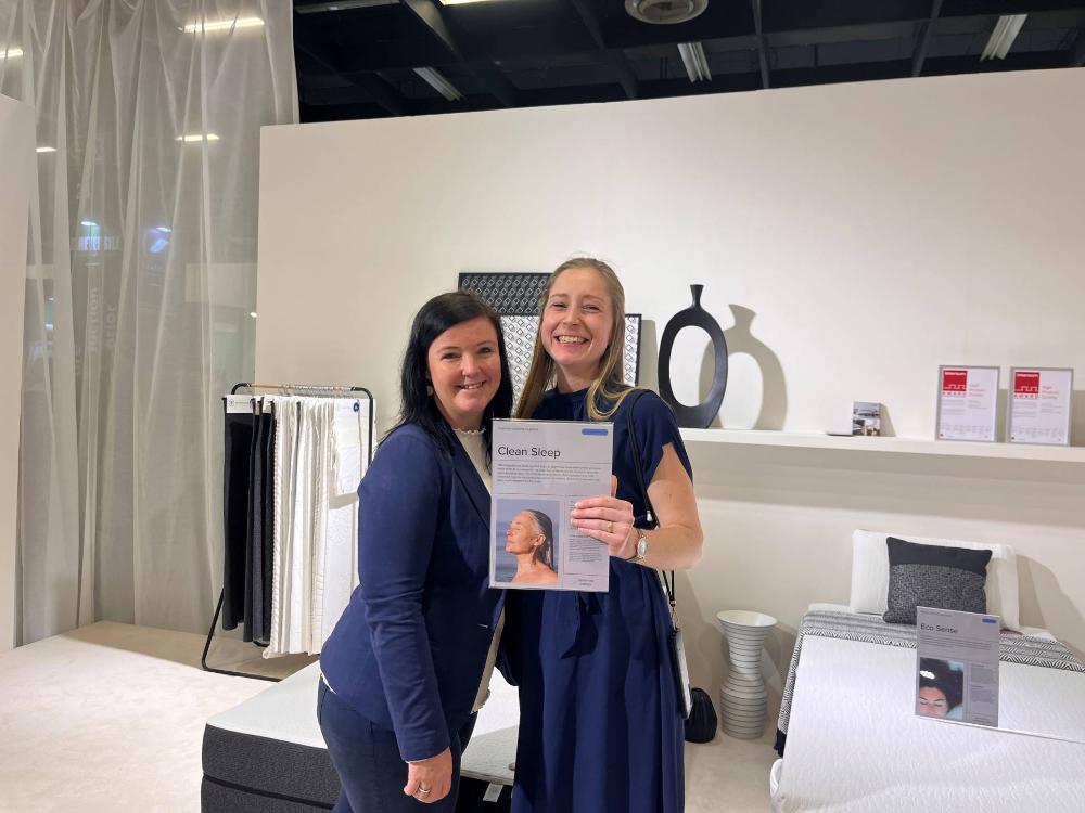 Two BekaertDeslee employees at a mattress industry event showcasing mattress textile solution