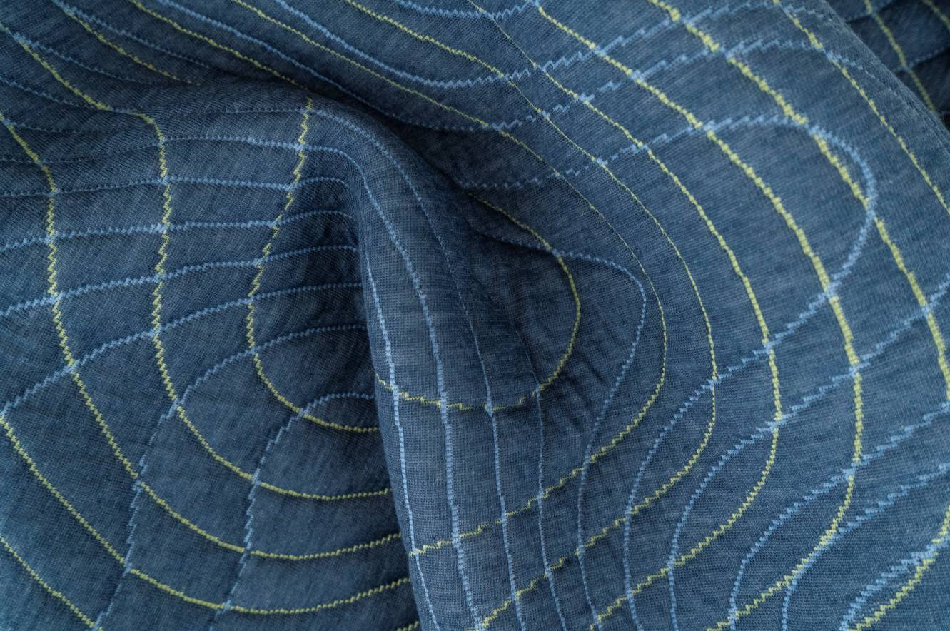 Blue mattress fabric with wavy yellow and light blue grid-like pattern