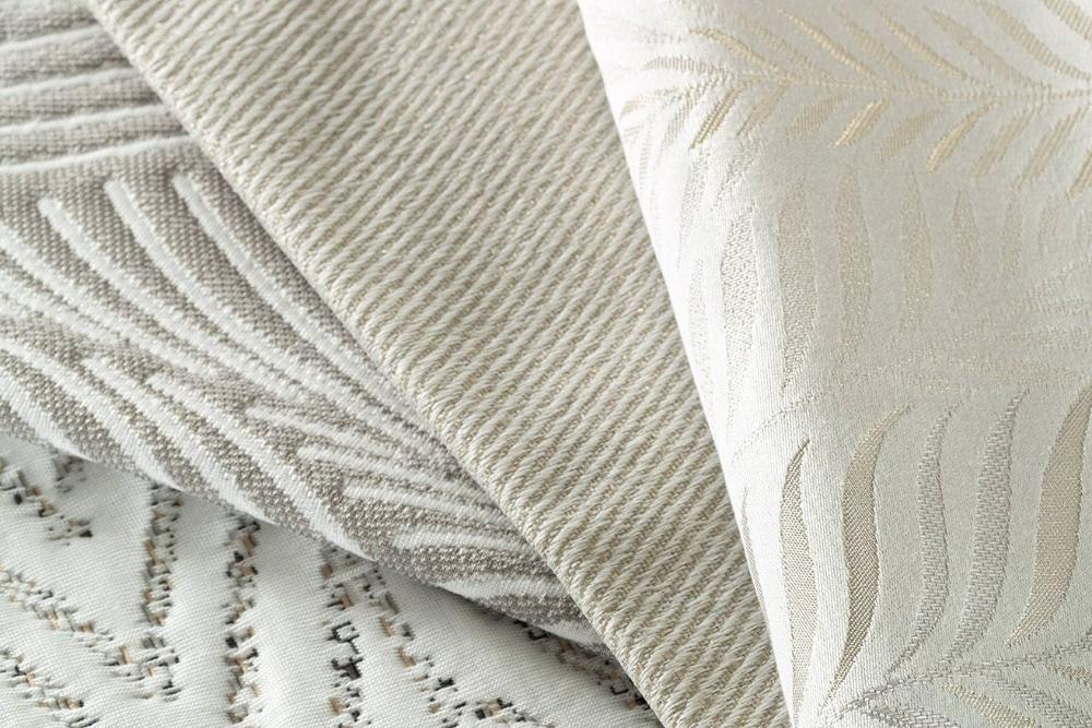 Textured mattress fabric samples in shades of beige, with leaf and ribbed designs