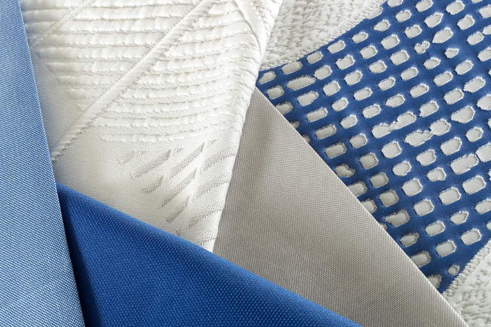 White and blue mattress fabric samples with geometric and textured patterns