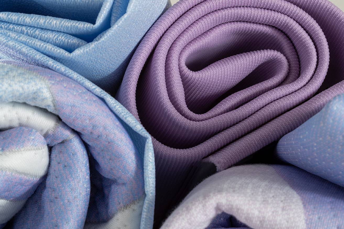folded grey, purple, and light blue fabric with soft and smooth textures.  