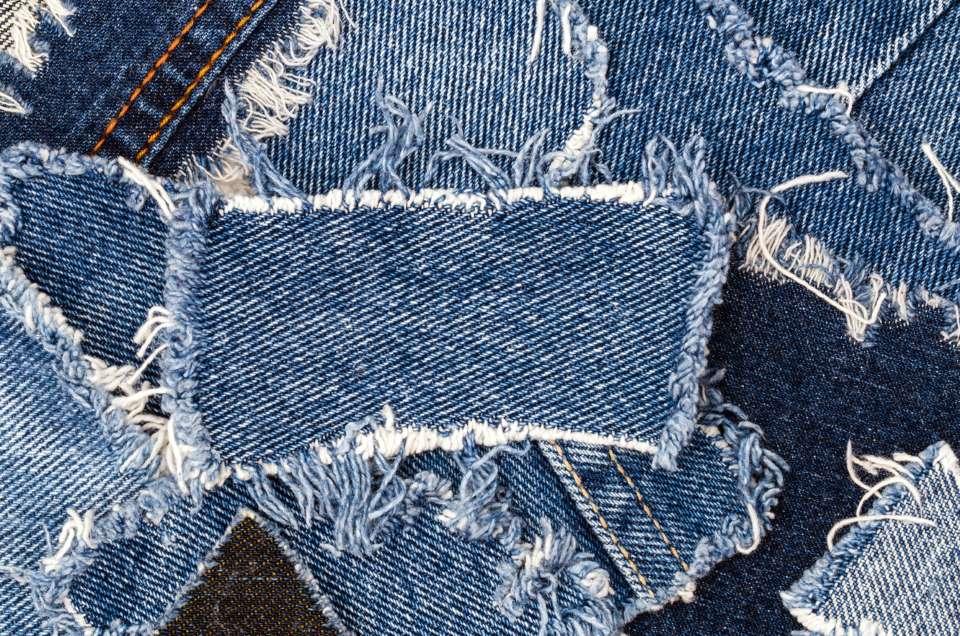 Rough, frayed denim fabric pieces used for recycling.