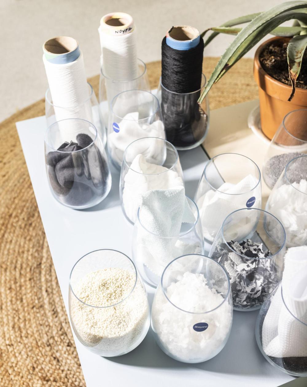 Various textile materials and threads in glass vases